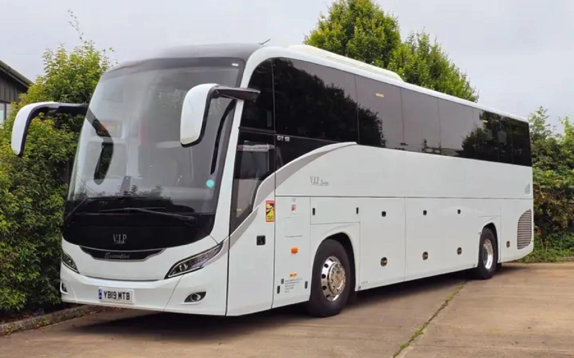 A sleek white YUTONG T122HDH luxury coach with a modern design, parked on a clean driveway.